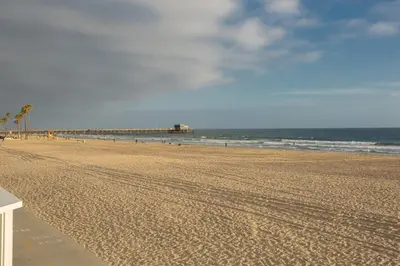 a sandy beach with a pier in the ocean at Newport Beach Oceanfront Home in Newport Beach