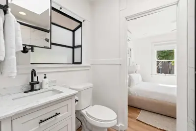 a white bathroom with a toilet and a sink at Cliff View - Prime Downtown La Jolla in San Diego