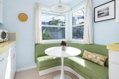 a kitchen with a white table and a green bench at Ocean Beach Bungalow - Close To Beach in San Diego