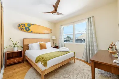 a bedroom with a bed and a surfboard on the wall at Ocean Beach Bungalow - Close To Beach in San Diego