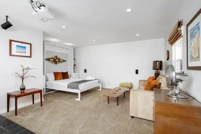 a living room with a couch and a bed at Ocean Beach Bungalow - Close To Beach in San Diego