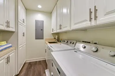 a kitchen with white cabinets and white appliances at Stroll to Shore Oceanside Condo with Hot Tub Access in Oceanside