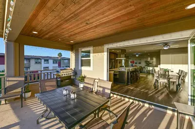 a patio with a table and chairs on a deck at Stroll to Shore Oceanside Condo with Hot Tub Access in Oceanside