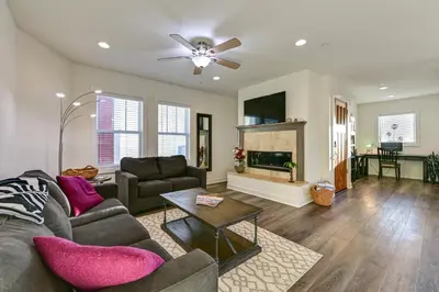 a living room with a couch and a fireplace at Stroll to Shore Oceanside Condo with Hot Tub Access in Oceanside