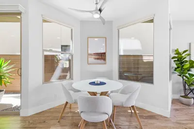 a white dining room with a white table and chairs at Elevated Coastal Living | Rooftop Deck Steps from Beach & Restaurants in San Diego