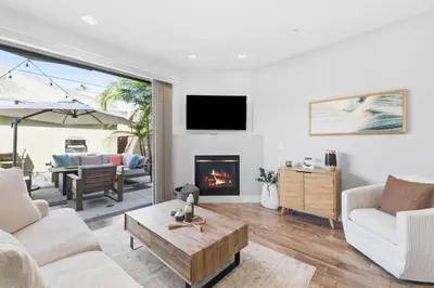 a living room with a couch and a fireplace at Elevated Coastal Living | Rooftop Deck Steps from Beach & Restaurants in San Diego