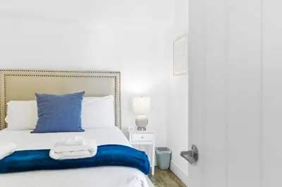a bedroom with a blue and white bed and a mirror at Elevated Coastal Living | Rooftop Deck Steps from Beach & Restaurants in San Diego