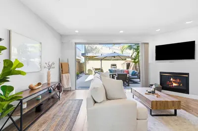 a living room with a couch and a fireplace at Elevated Coastal Living | Rooftop Deck Steps from Beach & Restaurants in San Diego