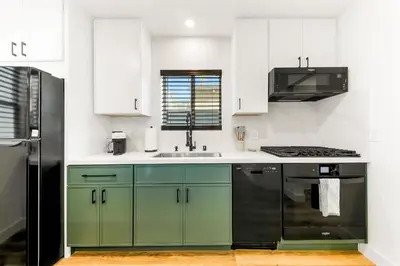 a kitchen with green cabinets and a black refrigerator at PB New Build - Steps to Sand & Surf in San Diego