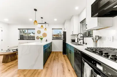 a kitchen with white walls and blue cabinets at PB NEW BUILD l A Block from SAND in San Diego