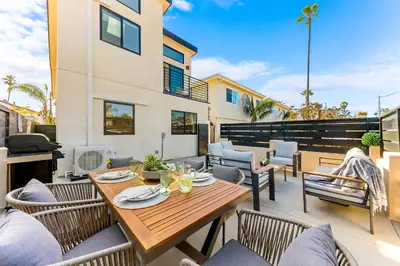 a patio with a wooden table and chairs at PB NEW BUILD l A Block from SAND in San Diego