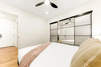 a bedroom with a bed and a large mirror at PB Beach Compound - 2 New Homes Steps to Sand in San Diego