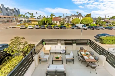 an apartment balcony with tables and chairs and a parking lot at PB Beach Compound - 2 New Homes Steps to Sand in San Diego