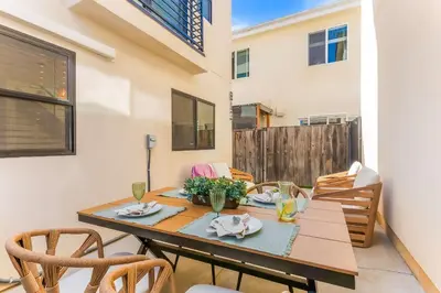 a dining room with a wooden table and chairs at PB Beach Compound - 2 New Homes Steps to Sand in San Diego