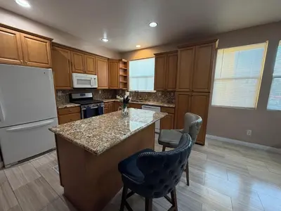 a kitchen with wooden cabinets and a white refrigerator at Private and Stylish 3Bdrm 3Ba Townhome, Gated Patio, King Bed, spacious in National City