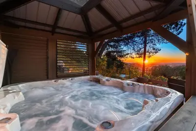 a jacuzzi tub with a sunset in the background at Sunset Summit by Coastline Vacation Rentals in La Mesa