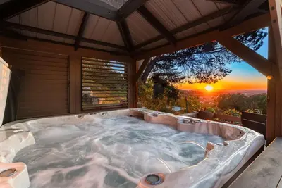 a hot tub with a sunset in the background at Sunset Summit by Coastline Vacation Rentals in La Mesa
