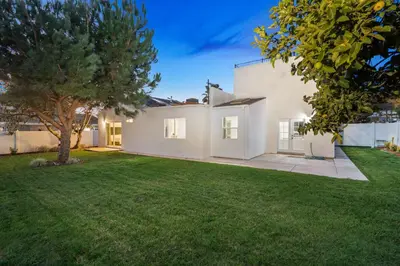 a large white house with a green yard at Spacious Modern Home with Rooftop & Private Backyard in Oceanside