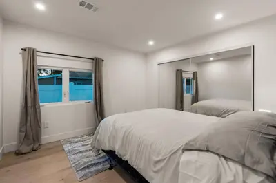 a bedroom with two beds and a large mirror at Spacious Modern Home with Rooftop & Private Backyard in Oceanside