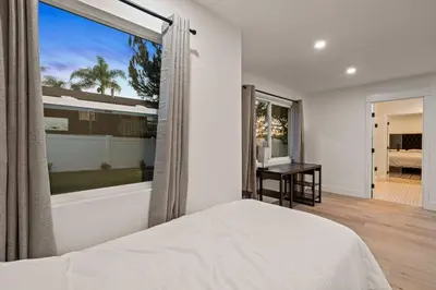 a bedroom with a bed and a large window at Spacious Modern Home with Rooftop & Private Backyard in Oceanside