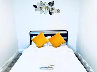 a bed with two yellow pillows and a flower on the wall at Uniktrend Campo Rd Home by SD Stay in Spring Valley