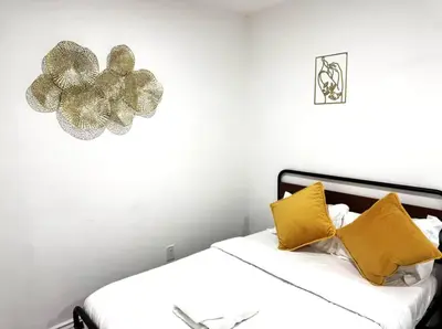 a bed with yellow pillows and a flower on the wall at Uniktrend Campo Rd Home by SD Stay in Spring Valley