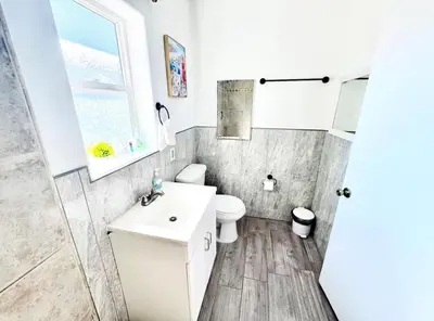 a bathroom with a toilet and a sink and a window at Uniktrend Campo Rd Home by SD Stay in Spring Valley