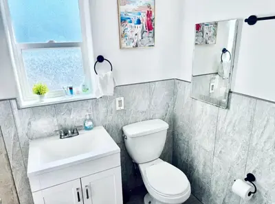 a bathroom with a toilet and a sink and a window at Uniktrend Campo Rd Home by SD Stay in Spring Valley