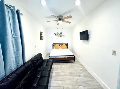 a bedroom with a couch and a ceiling fan at Uniktrend Campo Rd Home by SD Stay in Spring Valley