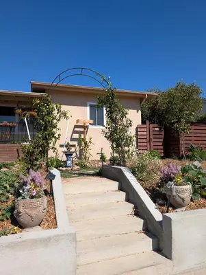 a staircase leading to a house with two potted plants at 2BR Cozy Quiet Getaway, Great Mattress in El Cajon