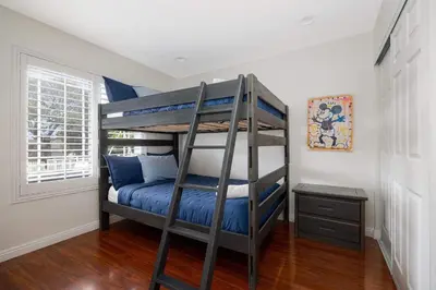 a bedroom with a bunk bed with blue sheets at Spacious Central Home Villa in San Diego