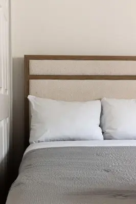 a bed with white pillows and a wooden headboard at Spacious Central Home Villa in San Diego