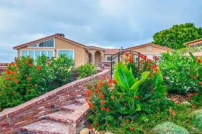 a house with a brick wall and some flowers at La Jolla private Studio in San Diego