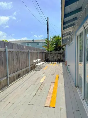 a wooden deck with a table and chairs on it at Entire Private Home with 3 Bedrooms 2 Bathrooms, Ranch Style w Gated Yard near Beach, Available Now in Imperial Beach