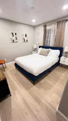 a bedroom with a large bed and a wooden floor at 321 W Park El Cajon Front Unit by SD Stay in El Cajon
