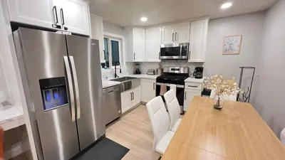 a kitchen with a table and a stainless steel refrigerator at 321 W Park El Cajon Front Unit by SD Stay in El Cajon