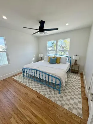 a bedroom with a blue bed and a ceiling fan at South O Surf House by Coastline Vacation Rentals in Oceanside