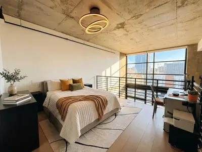 a bedroom with a bed and a desk and window at Penthouse Industrial Loft & Parking Little Italy in San Diego