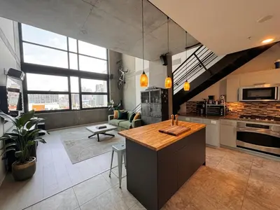 a kitchen with an island in a large room at Penthouse Industrial Loft & Parking Little Italy in San Diego
