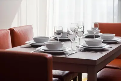 a wooden table with plates and wine glasses on it at Residence Inn by Marriott San Diego Downtown/Bayfront in San Diego