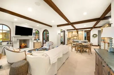 a living room with white furniture and a fireplace at The Stratford - Del Mar Luxury Living in San Diego