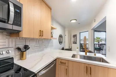 a kitchen with a sink and a microwave at Pier-View Penthouse Condo in Pacific Beach in San Diego