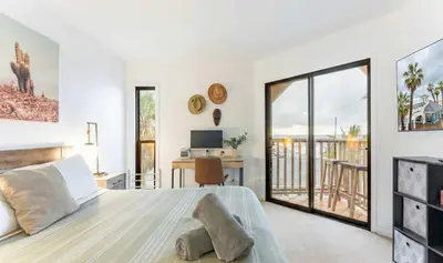 a bedroom with a large bed and a balcony at Pier-View Penthouse Condo in Pacific Beach in San Diego