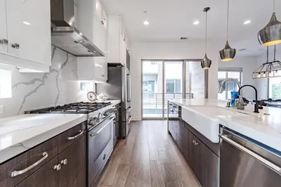 a kitchen with stainless steel appliances and wooden floors at #Marbella Lane - Luxurious Coastal Haven Escape in Newport Beach
