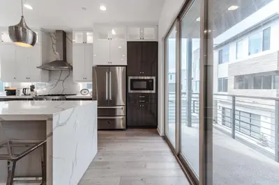 a kitchen with white cabinets and a large window at #Marbella Lane - Luxurious Coastal Haven Escape in Newport Beach