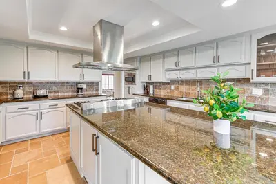 a kitchen with white cabinets and granite counter tops at Game Room, Hot Tub and Views! Luxe Temecula Estate in Temecula