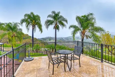 a patio with a table and chairs and palm trees at Game Room, Hot Tub and Views! Luxe Temecula Estate in Temecula