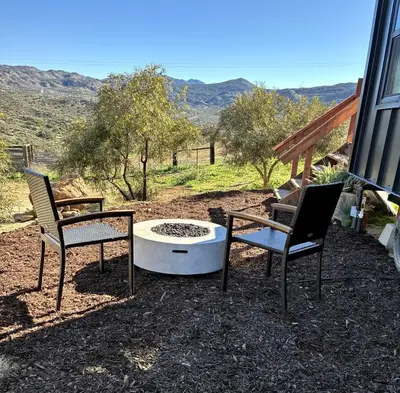two chairs and a fire pit in a yard at Unplug in a Rustic-Chic Tiny Home: Stargazing Patio, Cookout Space & Nature Views in Aguanga, California in Aguanga