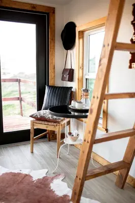 a room with a chair and a table and a ladder at Unplug in a Rustic-Chic Tiny Home: Stargazing Patio, Cookout Space & Nature Views in Aguanga, California in Aguanga