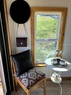 a room with a chair and a table and a window at Unplug in a Rustic-Chic Tiny Home: Stargazing Patio, Cookout Space & Nature Views in Aguanga, California in Aguanga